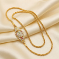 Gold necklace with a decorative clasp on a beige fabric background