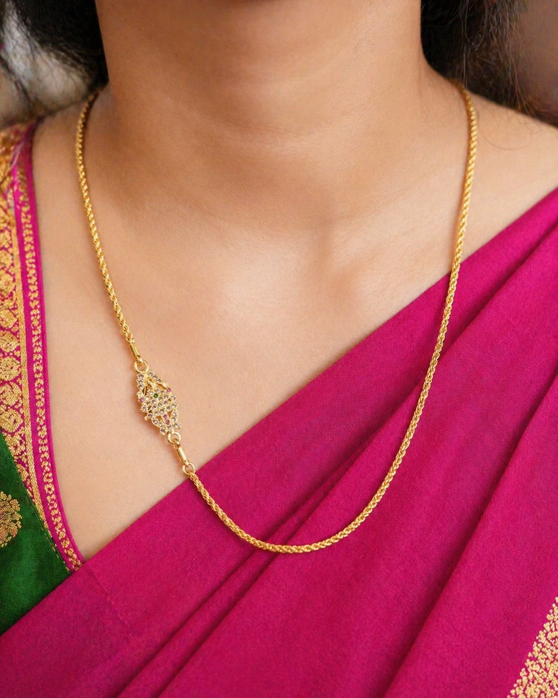 Gold necklace with a decorative clasp on a beige fabric background